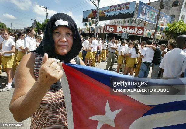 Una cubana se protege del sol simulando el pañuelo de cabeza de una iraquí durante un acto por el 42 aniversario de los acontecimientos de Playa...