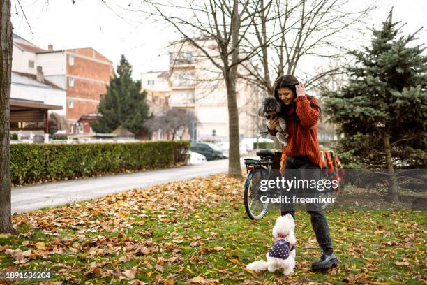 woman playing with her two pets in off- leash dog park - lead off stock pictures, royalty-free photos & images