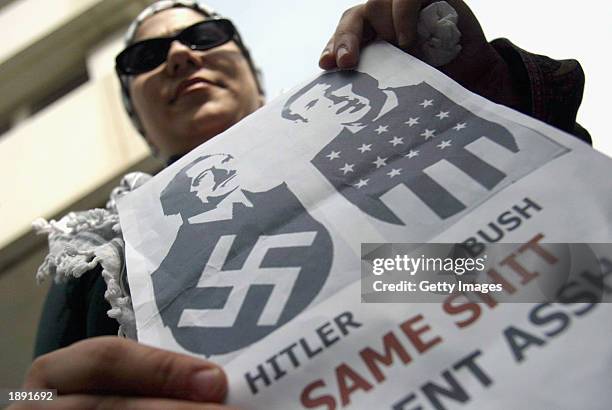 An Israeli Arab holds a poster showing U.S. President George W. Bush with Adolf Hitler as she protests against the war in Iraq April 2, 2003 outside...
