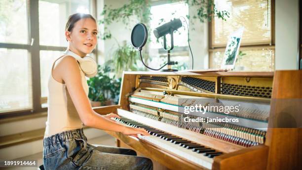 female pianist playing classical music on an old piano and singing - 10-11-years stock pictures, royalty-free photos & images