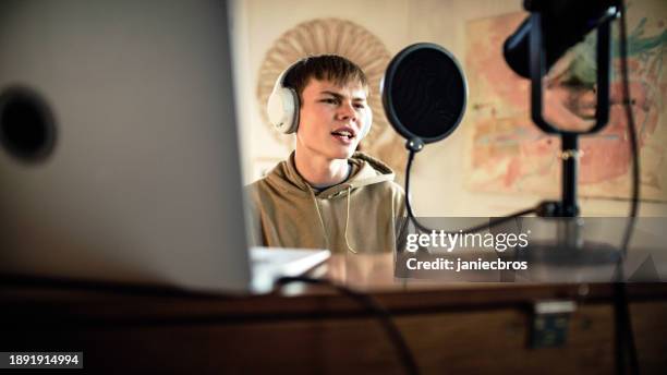 male student practicing singing lessons and playing rap background music on the laptop - rap background stock pictures, royalty-free photos & images