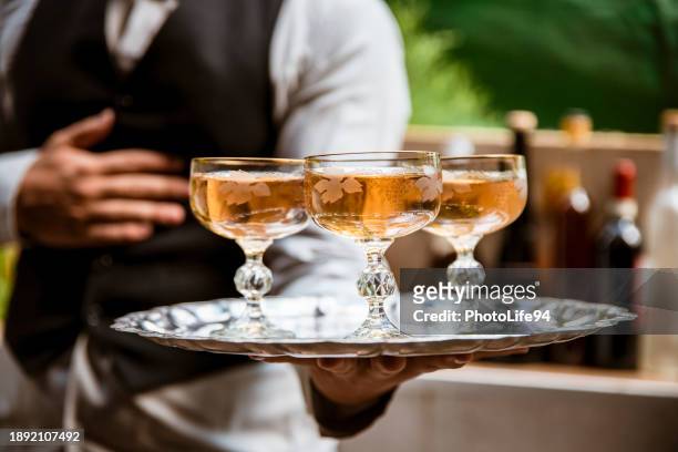 barman holding tray with white wine - service anniversary stock pictures, royalty-free photos & images