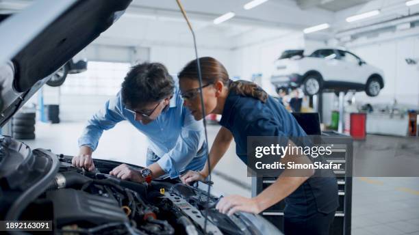 manager and mechanic examining car engine at workshop - conversation car bildbanksfoton och bilder
