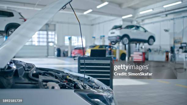 cars open bonnet with laptop placed next to engine in the auto repair shop - repair shop stock pictures, royalty-free photos & images