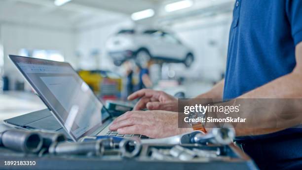 manager at the auto repair shop planning operations using laptop - repair garage stock pictures, royalty-free photos & images