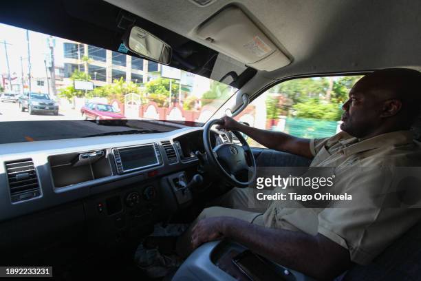 taxi driver driving on a sunny day in georgetown, capital of the country of guyana - motorista stock pictures, royalty-free photos & images
