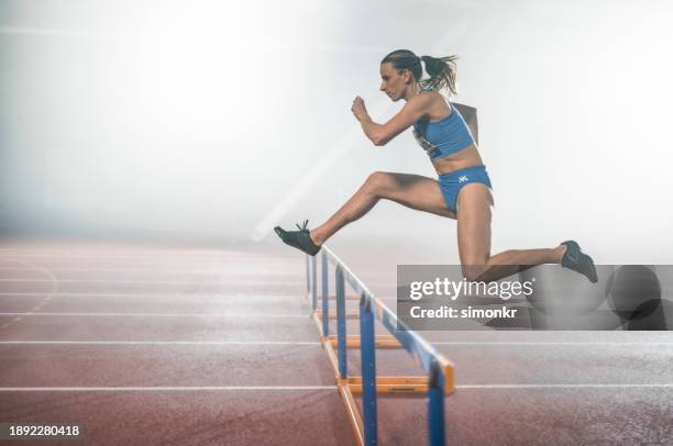 sportlerin springt über hürde - hürdenlauf laufdisziplin stock-fotos und bilder