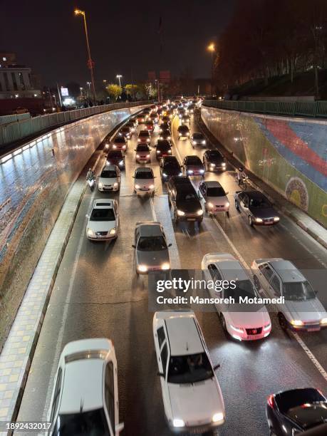 tehran, iran - december 14, 2023 - cars drive down the street at night - new delhi business district stock pictures, royalty-free photos & images