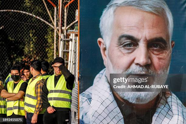 Youths stand next to a large banner depicting Qasem Soleimani, the slain commander of Iran's Islamic Revolutionary Guard Corps' Quds Force, who was...