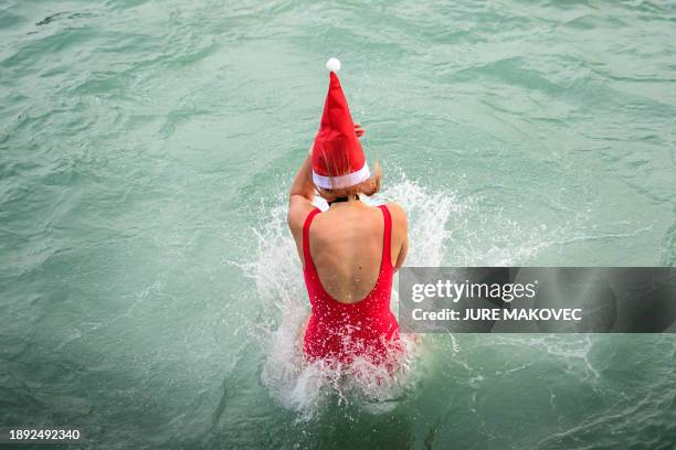 Woman jumps into the water during the traditional New Year's jump into the Adriatic sea in Portoroz, on January 1, 2024.
