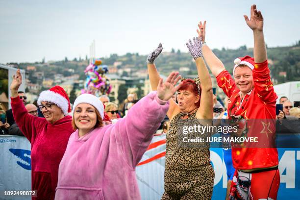 People warm up prior to jump into the water during the traditional New Year's jump into the Adriatic sea in Portoroz, on January 1, 2024.
