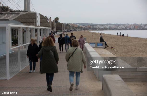 January 2024, Spain, Palma: People walk along the Arenal beach promenade in gloomy weather on New Year's Day. Temperatures on the Spanish island...