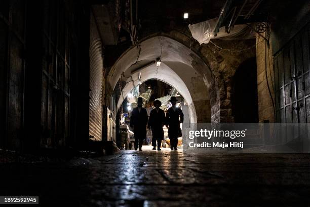 Ultra-Orthodox Jewish men walk in the Old City on December 29, 2023 in Jerusalem. Israel's PM Netanyahu announced an intensification of the fighting...
