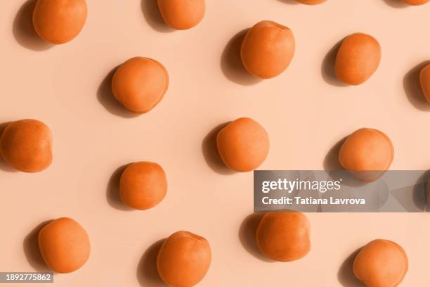 natural texture made by bright orange apricots on beige background. top view, flat lay. demonstrating peach color - trendy color 2024 - peach stock pictures, royalty-free photos & images