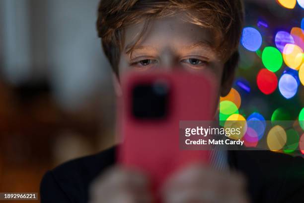 Year-old boy looks at an iPhone screen on December 19, 2023 in Bath, England. The amount of time children spend on screens each day rocketed during...