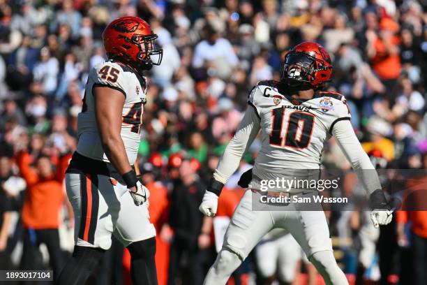 Defensive lineman Semisi Saluni and outside linebacker Andrew Chatfield Jr. #10 of the Oregon State Beavers celebrate after Chatfield Jr. Sacked...