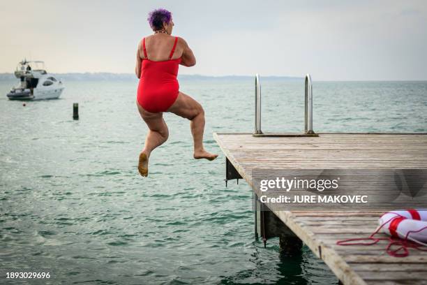 Woman jumps into the water during the traditional New Year's jump into the Adriatic sea in Portoroz, on January 1, 2024.