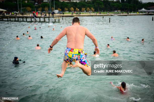 Man jumps into the water during the traditional New Year's jump into the Adriatic sea in Portoroz, on January 1, 2024.