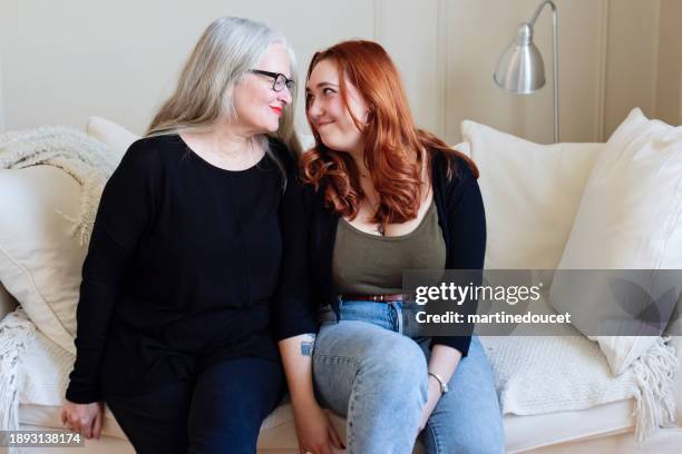 senior mother and adult daughter self-portrait on living-room sofa - body image stock pictures, royalty-free photos & images