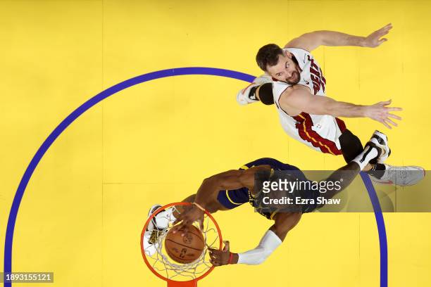 Jonathan Kuminga of the Golden State Warriors dunks the ball on Kevin Love of the Miami Heat at Chase Center on December 28, 2023 in San Francisco,...