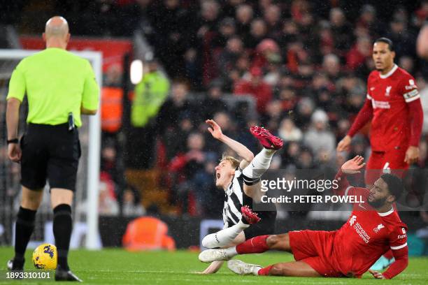 Liverpool's English defender Joe Gomez slides in to tackle Newcastle United's English midfielder Anthony Gordon during the English Premier League...