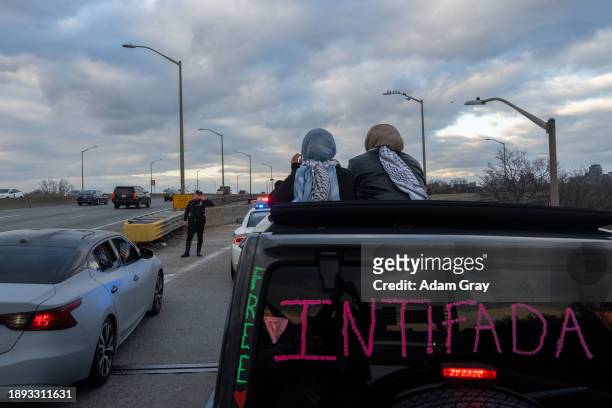New York Police Department officers block a slip road as supporters of Palestine drive in convoy near LaGuardia Airport as they targeted JFK and...