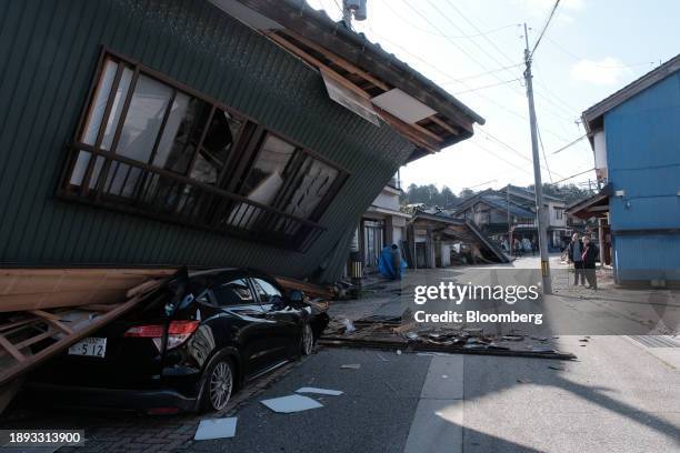 Damaged vehicle under a collapsed house following an earthquake in Nanao, Ishikawa Prefecture, Japan, on Tuesday, Jan. 2, 2024. At least 13 people...