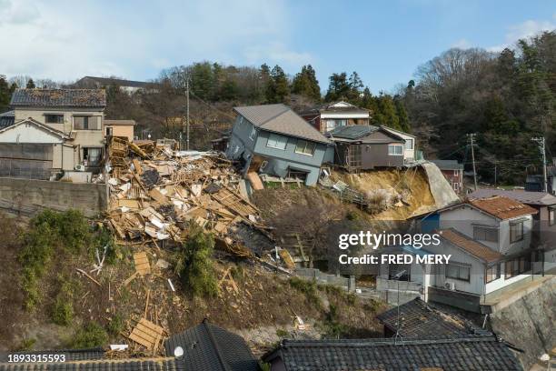 Damaged houses, including one totally collapsed , are pictured along a street in Wajima, Ishikawa prefecture on January 2 a day after a major 7.5...