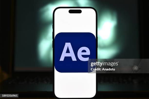 In this photo illustration logo of an 'Adobe' app is displayed on a mobile screen in front of a computer screen in Ankara, Turkiye on December 28,...