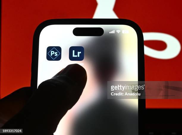 In this photo illustration logos of 'Adobe' apps are displayed on a mobile screen in front of logo of 'Adobe' on a computer screen in Ankara, Turkiye...