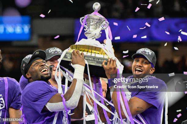 Washington Huskies defensive end Bralen Trice and Washington Huskies quarterback Michael Penix Jr. Raise the trophy for winning the Semifinal All...