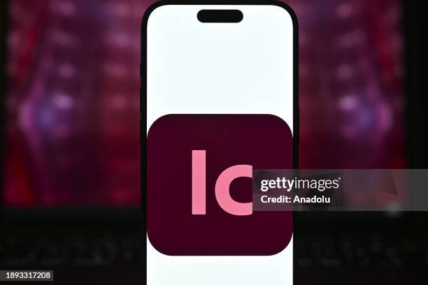 In this photo illustration logo of an 'Adobe' app is displayed on a mobile screen in front of a computer screen in Ankara, Turkiye on December 28,...