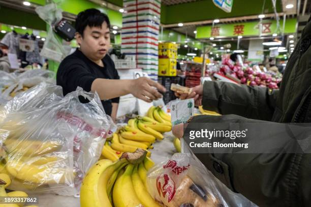 Vendor sells banana at a wet market in Beijing, China, on Tuesday, Jan. 2, 2024. Chinese President Xi Jinping pledged to strengthen economic momentum...
