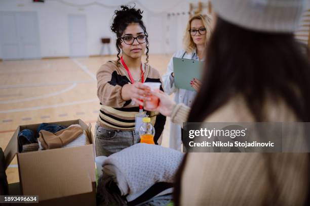 refugees at a help center - man holding donation box stock pictures, royalty-free photos & images