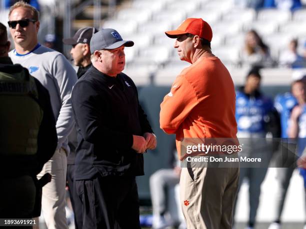 Head Coaches Mark Stoops of the Kentucky Wildcats and Dabo Swinney of the Clemson Tigers talk at mid-field before the start of the 79th annual...
