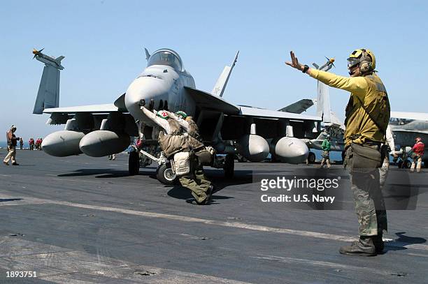 Sailors push an F/A-18E Super Hornet to aid the handlers in directing it around the flight deck aboard USS Abraham Lincoln. Lincoln and Carrier Air...