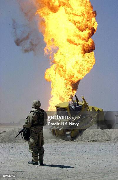 Army soldier stands guard duty near a burning oil well April 2, 2003 in the Rumaylah Oil Fields in Southern Iraq. Coalition forces have successfully...