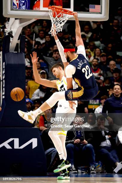 Larry Nance Jr. #22 of the New Orleans Pelicans dunks the ball over Walker Kessler of the Utah Jazz during the fourth quarter of an NBA game at...
