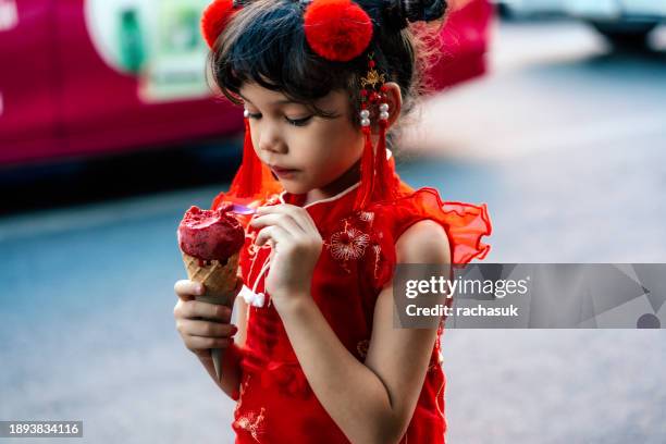 schönes kleines mädchen in traditioneller chinesischer kleidung mit eistüte - girl eating messy ice cream cone stock-fotos und bilder