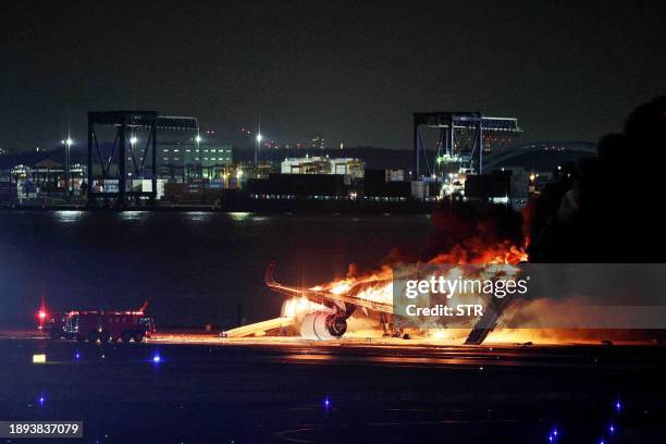 This photo provided by Jiji Press shows a Japan Airlines plane on fire on a runway of Tokyo's Haneda Airport on January 2, 2024. A Japan Airlines...
