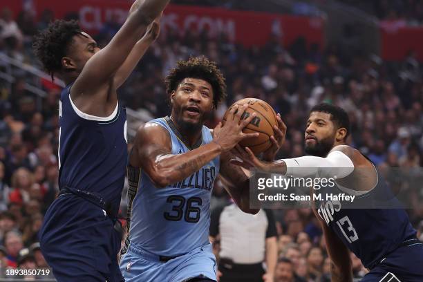 Marcus Smart of the Memphis Grizzlies splits the defense of Paul George and Kobe Brown of the LA Clippers during the first half of a game at...