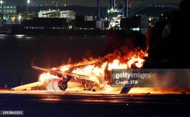 This photo provided by Jiji Press shows a Japan Airlines plane on fire on a runway of Tokyo's Haneda Airport on January 2, 2024. A Japan Airlines...