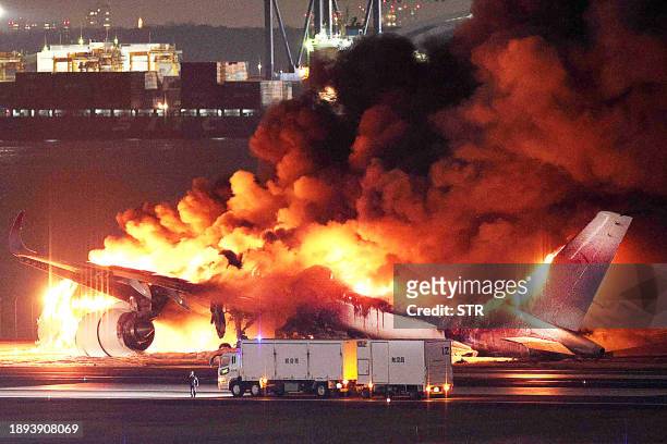 This photo provided by Jiji Press shows a Japan Airlines plane on fire on a runway of Tokyo's Haneda Airport on January 2, 2024. A Japan Airlines...