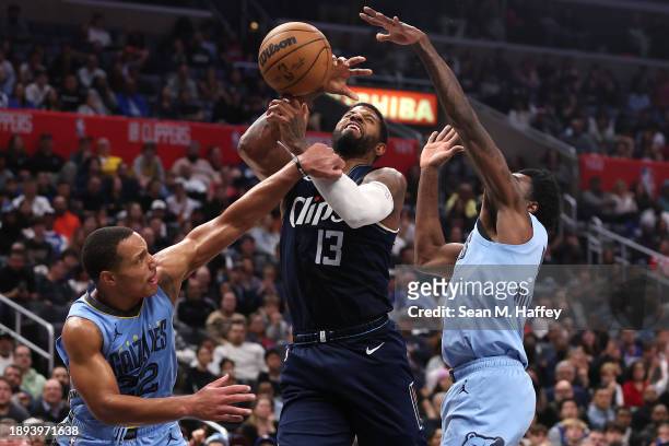 Paul George of the LA Clippers battles Desmond Bane and Vince Williams Jr. #5 of the Memphis Grizzlies for a rebound during the second half of a game...