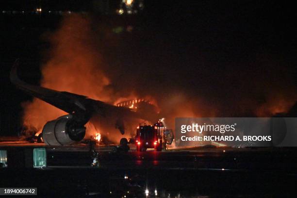 Japan Airlines passenger plane is seen on fire on the tarmac at Tokyo International Airport at Haneda on January 2, 2024. A Japan Airlines plane...