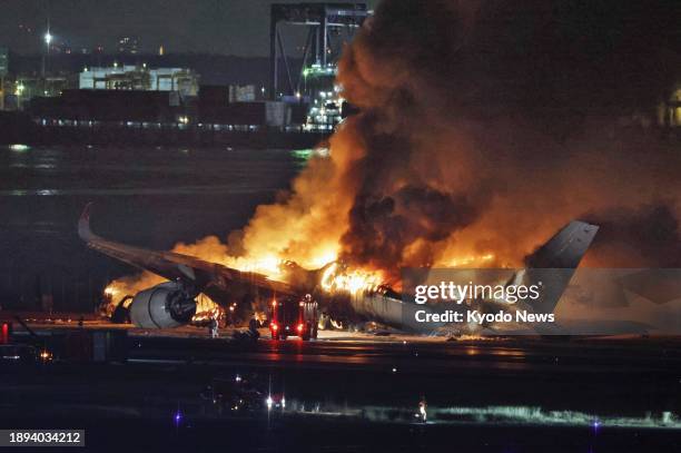 Photo taken on Jan. 2 shows a Japan Airlines aircraft on fire on a runway at Haneda airport in Tokyo after it apparently collided with a Japan Coast...