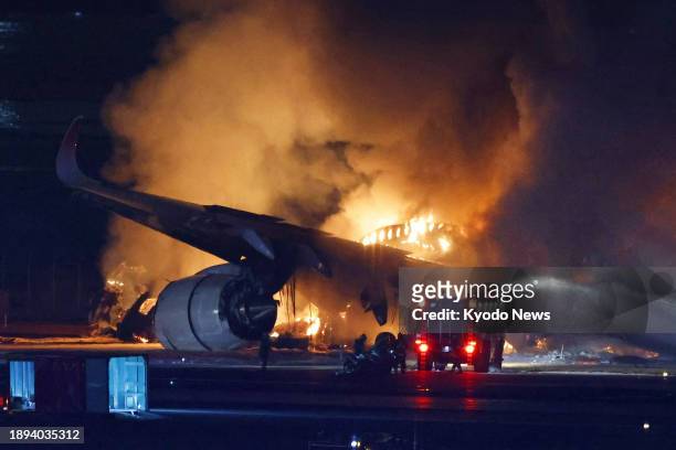 Photo taken on Jan. 2 shows a Japan Airlines aircraft on fire on a runway at Haneda airport in Tokyo after it apparently collided with a Japan Coast...