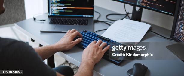 lo sviluppatore maschio americano dell'ingegnere del software usa il computer portatile nell'ufficio di casa, lavora sulla codifica del programma applicativo. tecnologia di sviluppo del linguaggio di programmazione, lavoro freelance, vista sopra la spalla - programmazione televisiva foto e immagini stock