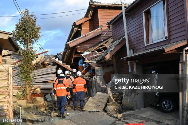 Firefighters inspect collapsed wooden houses in Wajima, Ishikawa prefecture on January 2 a day after a major 7.5 magnitude earthquake struck the Noto...