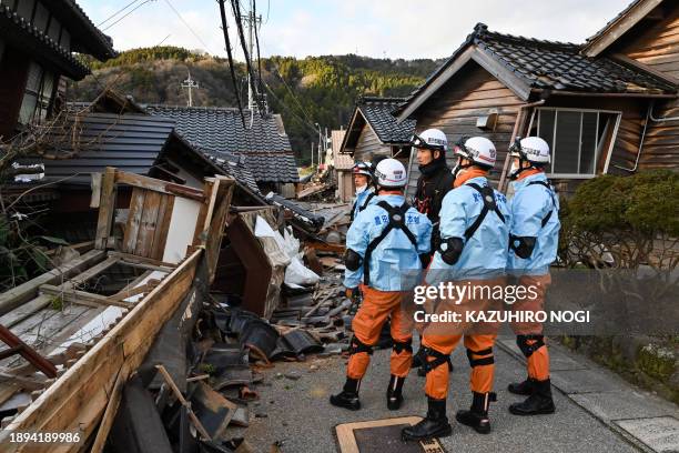 Firefighters inspect collapsed wooden houses in Wajima, Ishikawa prefecture on January 2 a day after a major 7.5 magnitude earthquake struck the Noto...